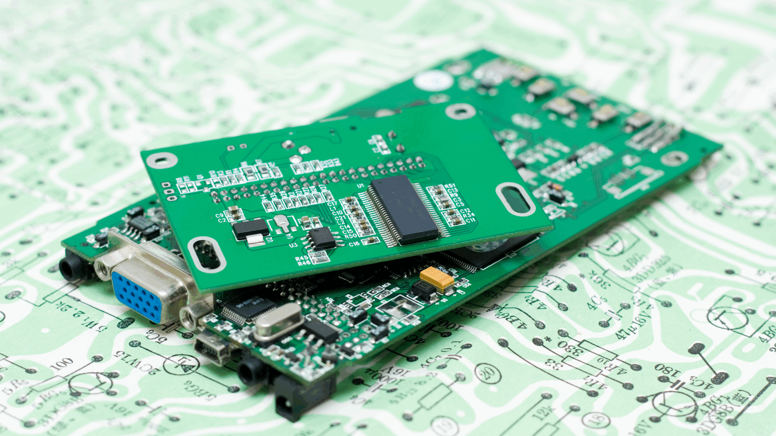 Plusieurs circuits imprimés (PCB) empilés sur un schéma électronique, illustrant le processus de fabrication.