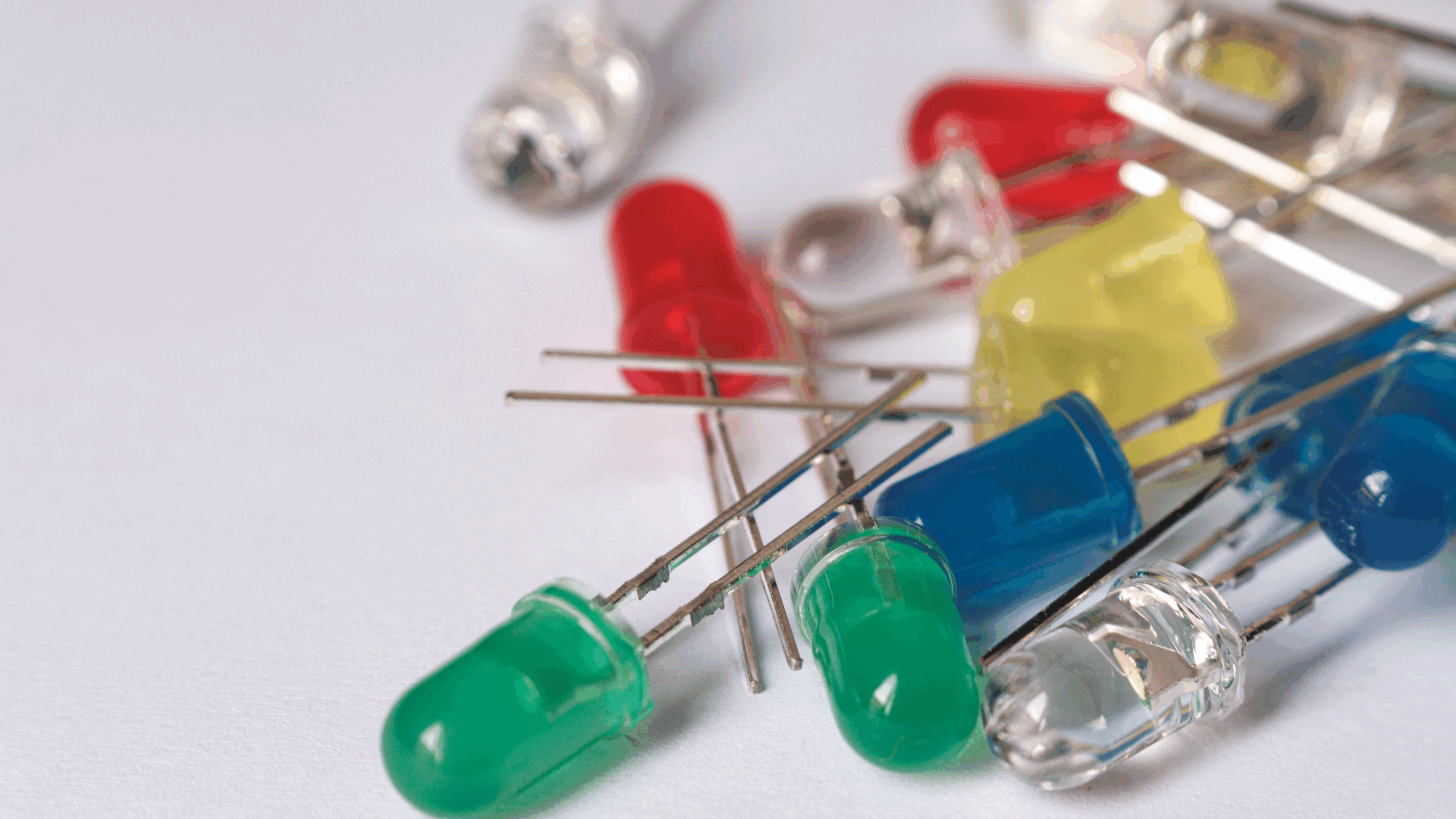Un assortiment de diode électroluminescente ou LED de différentes couleurs (rouge, jaune, vert et bleu) sur un fond clair.