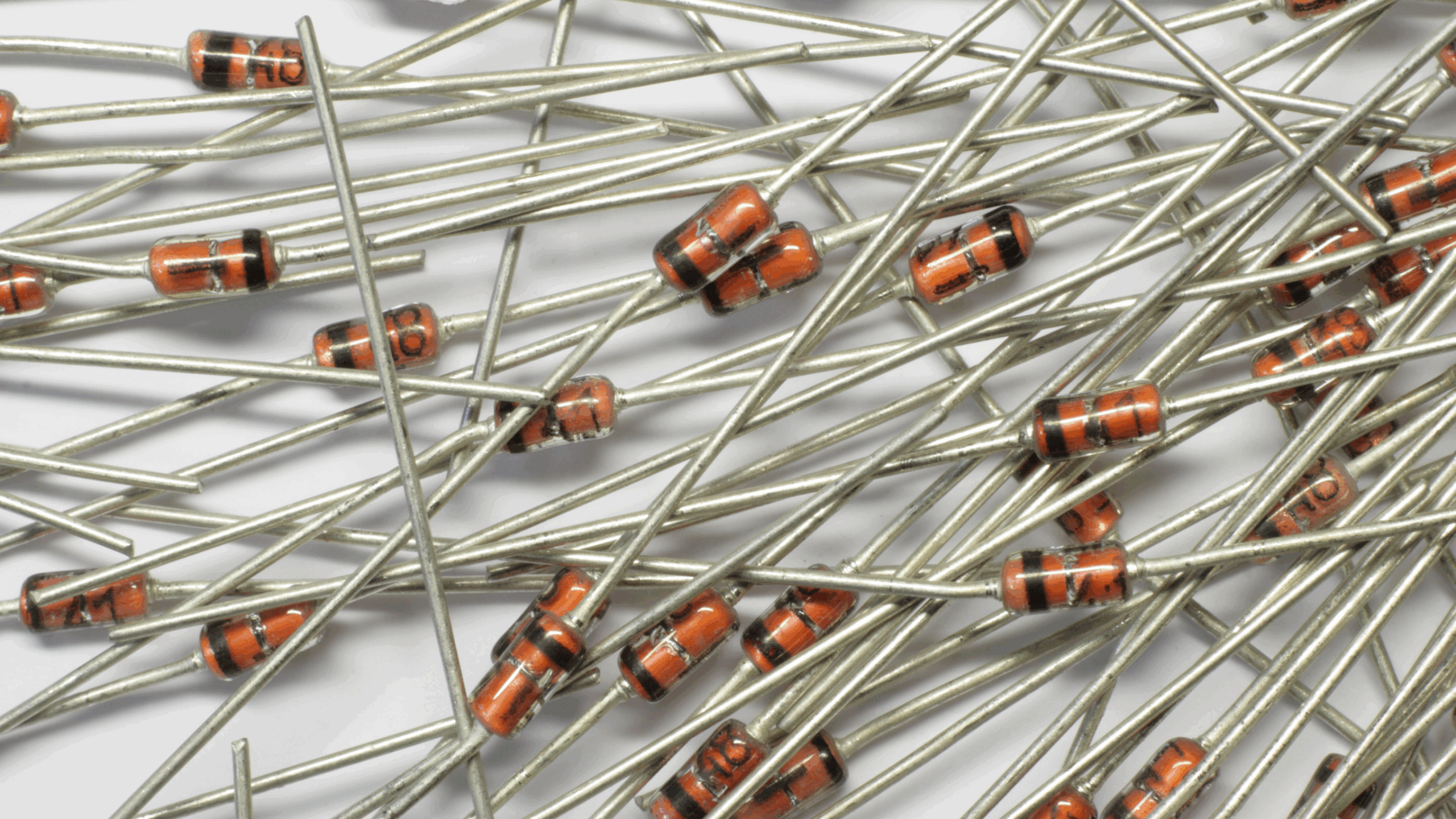 Diode Zener Gros plan sur un groupe de diodes Zener, de petits composants électroniques cylindriques avec une bande de couleur pour indiquer leur polarité, disposées sur un fond flou.