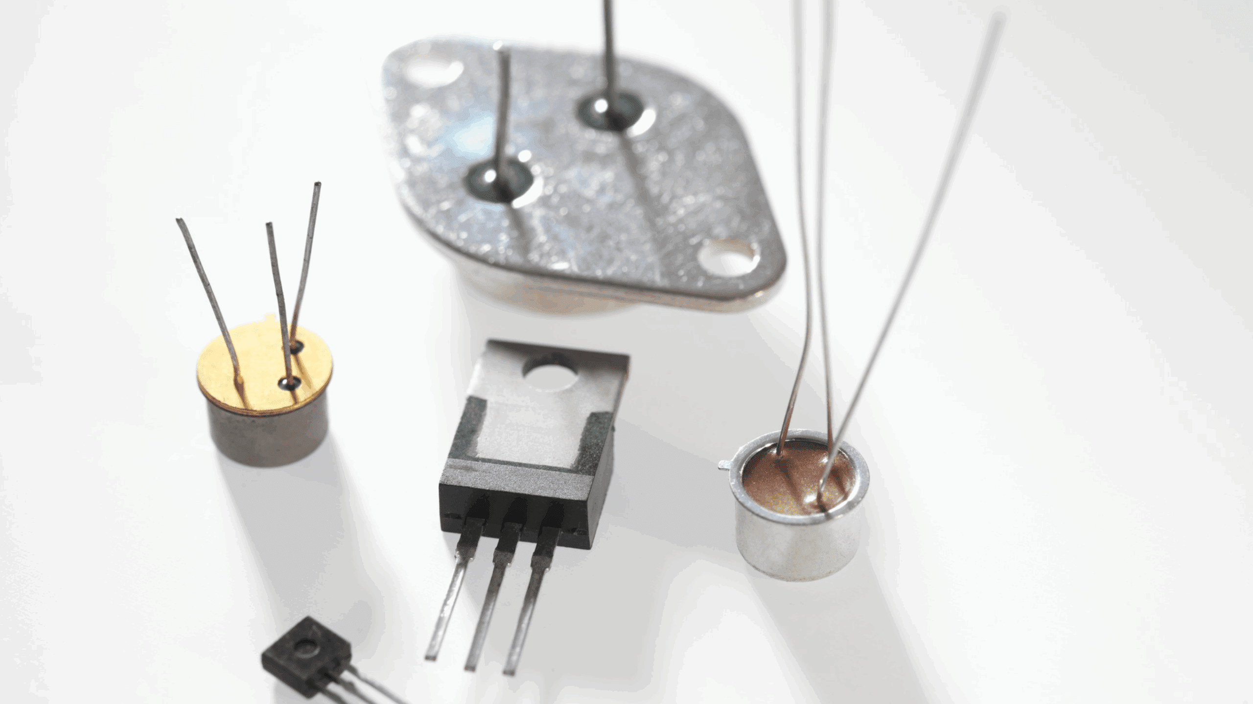 Gros plan d'un transistor bipolaire (BJT) sur un établi d'électronique, illustrant l'un des principaux composants du cours.