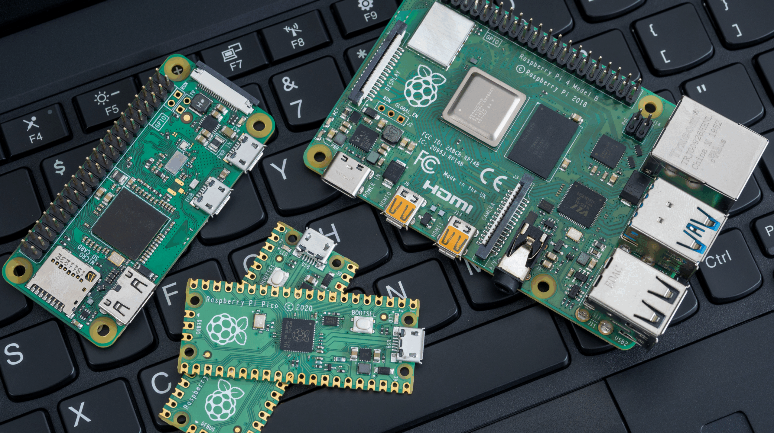 Différentes cartes Raspberry Pi (Pi 4, Pi Zero et Pico) posées sur un clavier, illustrant le matériel à protéger.
