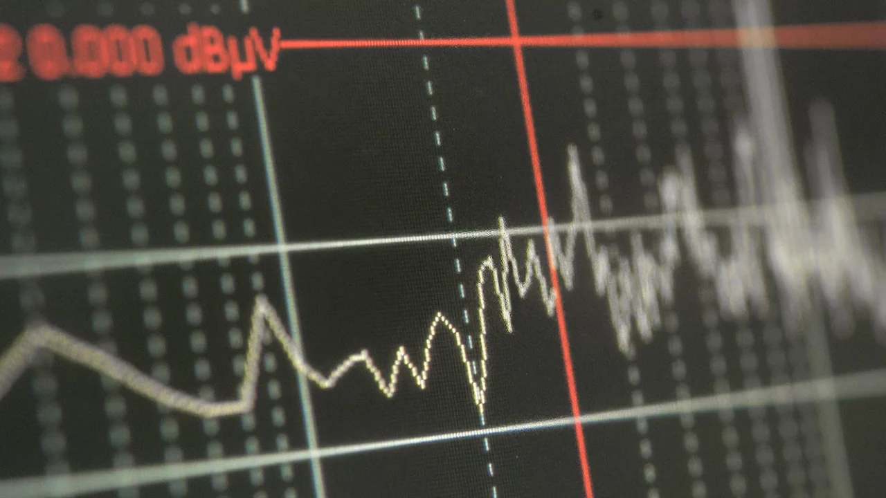 Écran d'analyseur de spectre affichant un graphique de bruit électromagnétique avec des pics mesurés en dBµV, illustrant une étape de mesure en conception PCB CEM.